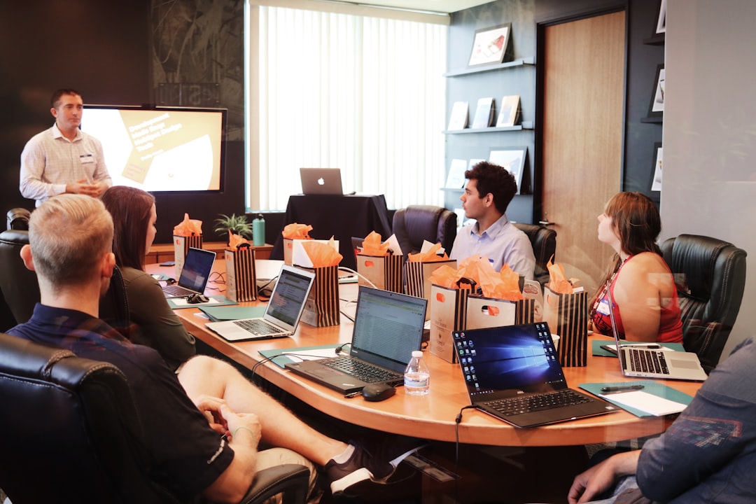 Staff seated around a table with laptops during an AI training and adoption workshop