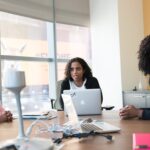 Team working together around a table with laptops in an office