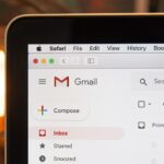 Laptop screen showing an email inbox on a desk