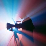 Camera on a tripod filming under stage lighting