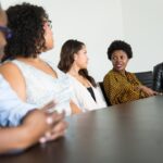 Five colleagues sitting around a table in discussion